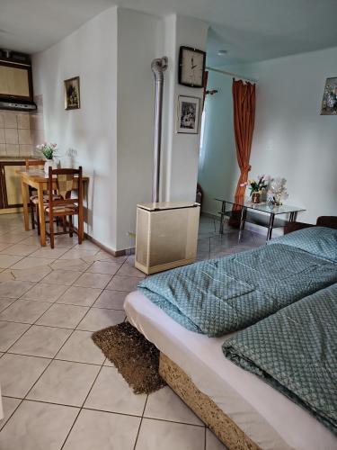a bedroom with a bed and a dining room with a table at Horváth kuckó in Fonyód