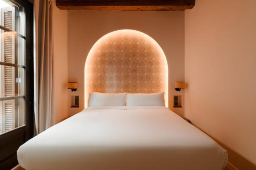 a bedroom with a bed and a large window at Hotel Hamsa House in Barcelona