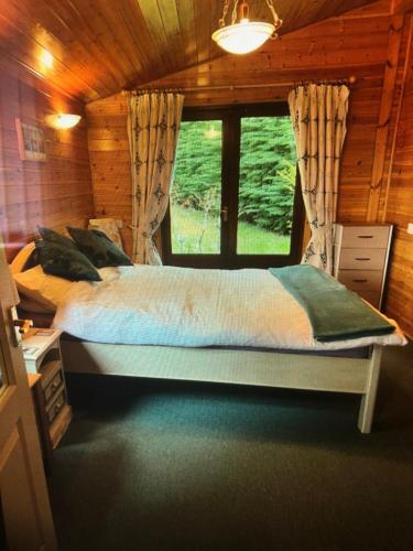 a bedroom with a large bed with a window at ballyskelly lodge in Jemimaville