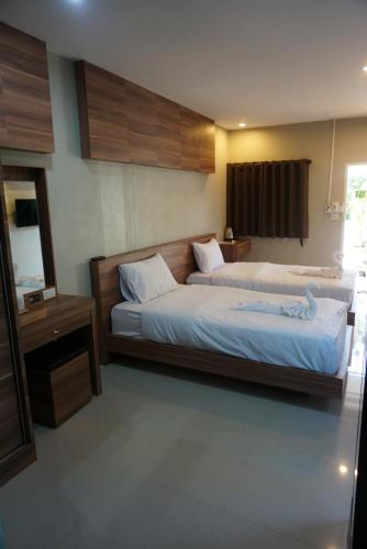 a hotel room with two beds and a mirror at The Rhea in Udon Thani