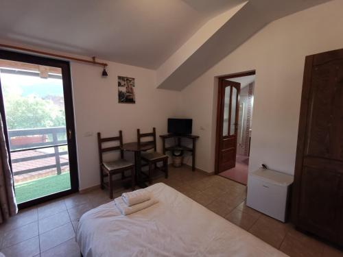 a bedroom with a bed and a table and a window at Casa Juliana in Rîu Bărbat
