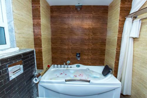 a bathtub in a bathroom with a wooden wall at Kathmandu Suite Home in Kathmandu