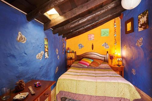 a bedroom with a bed and a blue and yellow wall at Casitas Manuel in El Paso