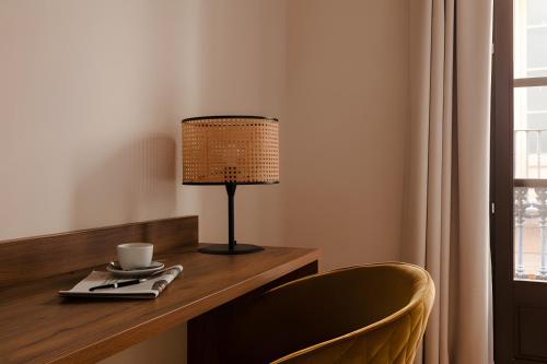a table with a lamp and a cup on it at Hotel Hamsa House in Barcelona