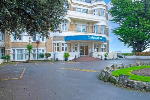 a building with a parking lot in front of it at Bournemouth Carlton Hotel By Sunday in Bournemouth