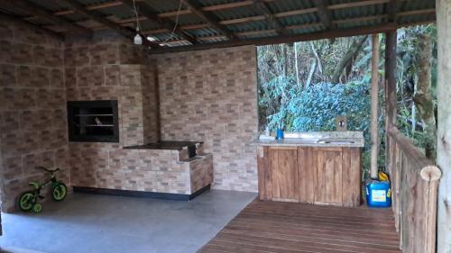 a room with a kitchen and a wooden deck at Chalé do Beleza - Serra do Corvo in Braço do Norte