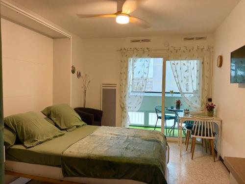 a bedroom with a bed and a dining room with a table at Studio 25m2 à deux pas des thermes in Balaruc-les-Bains