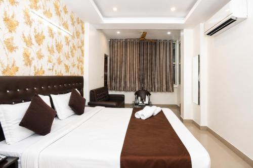 a hotel room with a large bed and a chair at Hotel Golden Ring in Lucknow