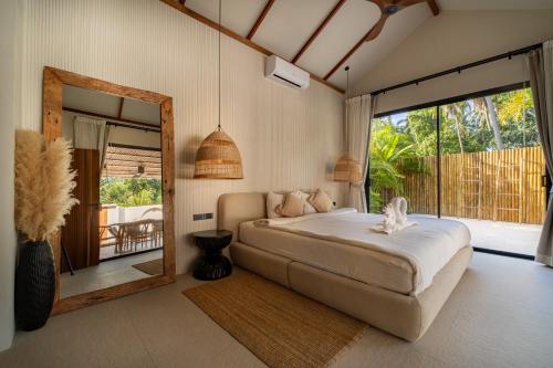 a bedroom with a bed and a large window at K Villas Phangan 01 in Thong Sala