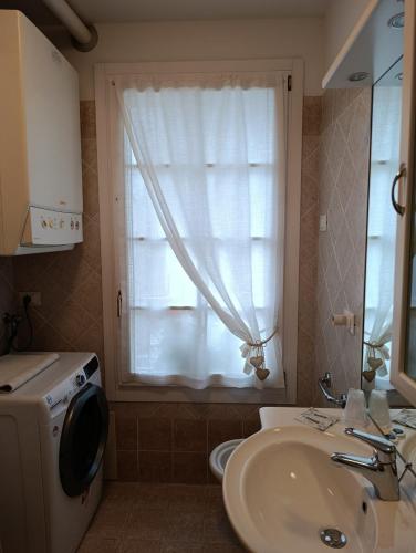 a bathroom with a sink and a window at Appartamento Marmolada in Pieve di Livinallongo