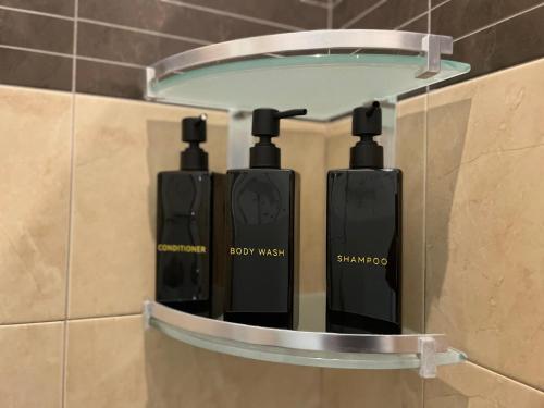 a shelf in a bathroom with two black soap dispensers at Suites Asia in Argelato