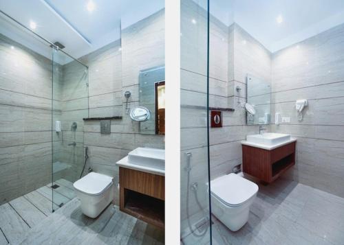 two pictures of a bathroom with a toilet and a sink at Aura Grand Amritsar in Amritsar
