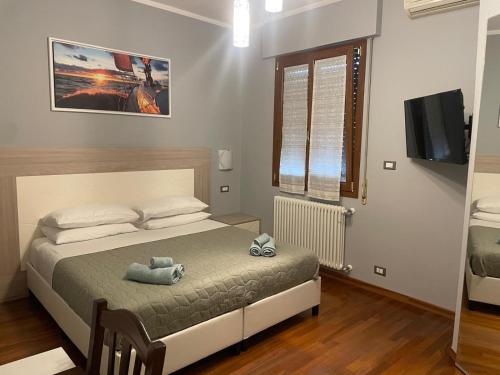 a bedroom with a bed and a flat screen tv at Suites Asia in Argelato