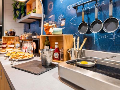 a kitchen counter with a sink and utensils at Hôtel Mercure Lyon Centre Lumière in Lyon