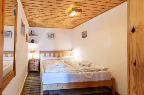 a bedroom with a bed and a wooden ceiling at Haus Ottomar in Wieck
