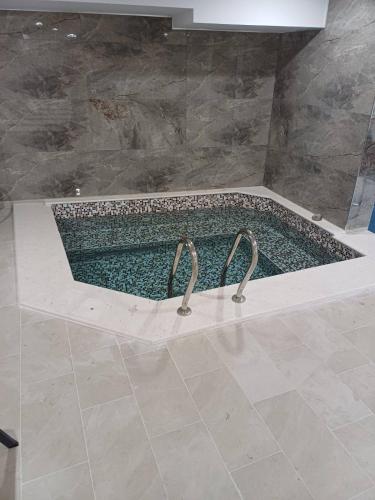 a bath tub with two faucets in a bathroom at Hotel Deyanira in Gorno Dryanovo