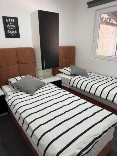 two beds in a room with a tv on the wall at Holiday Home Orsag in Drage