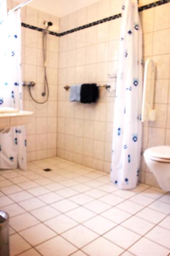a bathroom with a shower and a toilet at Haus Witten Höhen Ferienwohnungen in Cuxhaven