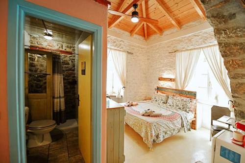 a bedroom with a bed and a bathroom with a toilet at Mastoris Mansion in Hydra