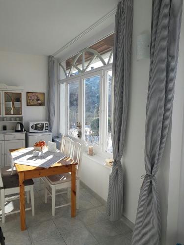 a dining room with a table and a window at Zsigmond Vendégház in Villány