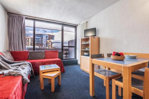 a living room with a red couch and a table at Résidence Pierre & Vacances Inter-Résidences in Tignes