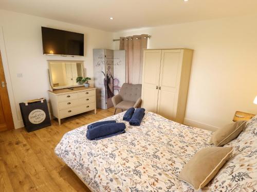 a bedroom with a bed with two blue pillows on it at The New Build in Louth