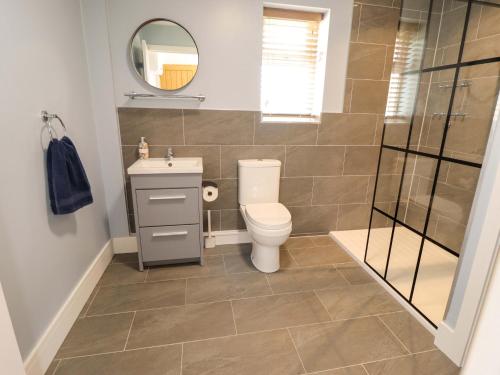 a bathroom with a toilet and a sink and a mirror at The New Build in Louth