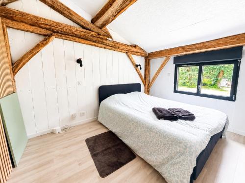 a bedroom with a bed in a room with wooden beams at Les cabanes in Noaillan
