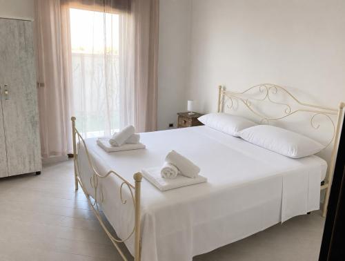 a bedroom with a white bed with two towels on it at Casa Ulivo in Pulsano