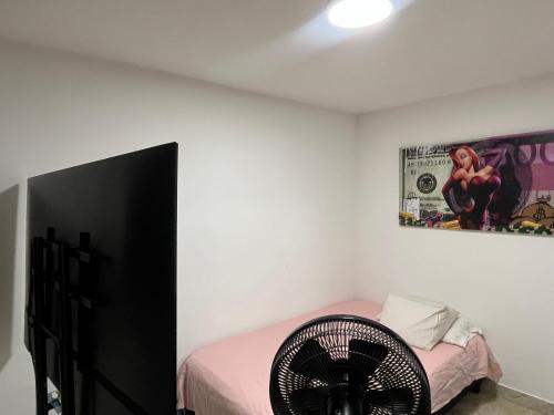 a bedroom with a bed and a fan at Ciudad Guabinas in Yumbo
