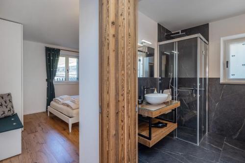 a bathroom with a glass shower and a sink at Shasta Mountain Lodge in Cavalese