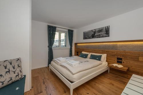 a bedroom with a bed and a chair in it at Shasta Mountain Lodge in Cavalese