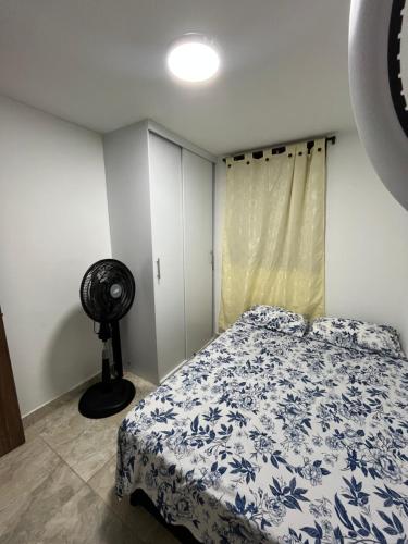 a bedroom with a bed with a blue and white blanket at Ciudad Guabinas in Yumbo