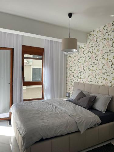 a bedroom with a large bed with a floral wall at Bluvera in Šušanj