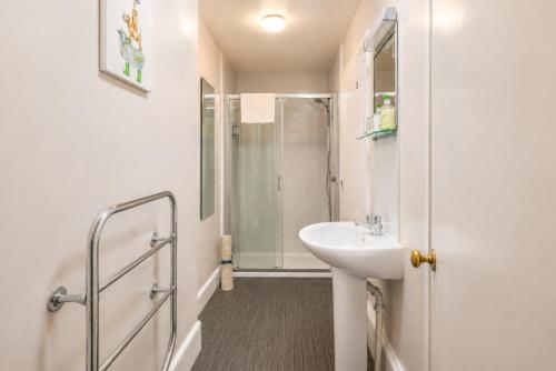 a white bathroom with a shower and a sink at The Ardyne Guest House in Rothesay