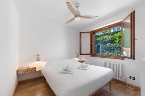 a bedroom with a white bed and a window at Lake Suite in Miasino