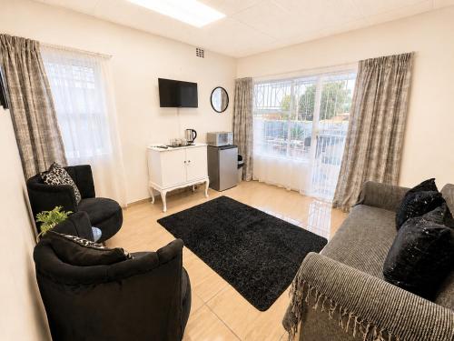 a living room with two chairs and a couch at Zhantique Guest House 2- Unit 10 in Boksburg