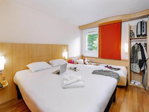 a hotel room with two beds and a window at ibis Mulhouse Centre Filature in Mulhouse