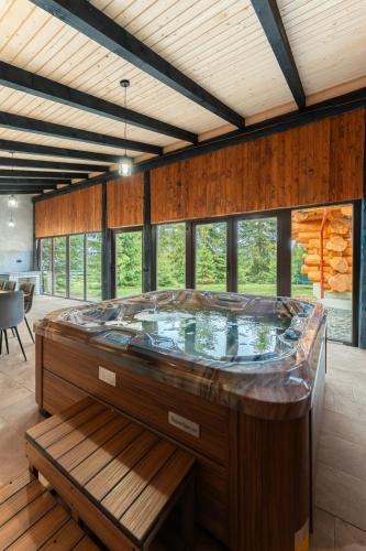 a jacuzzi tub in a room with wooden walls at Dor De Munte in Mărişel