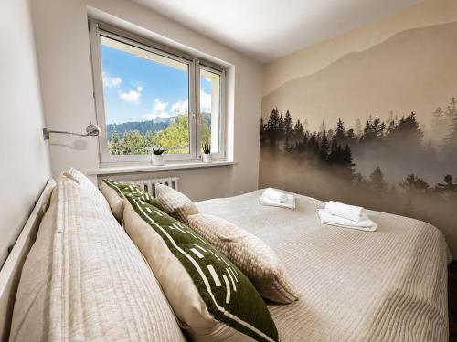a bedroom with a bed with pillows and a window at Apartament Wisła Centrum in Wisła