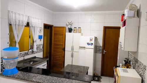 a kitchen with a refrigerator and a counter top at Casa Martinez in Mongaguá