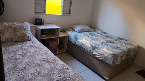 a bedroom with two beds and a desk at Casa Martinez in Mongaguá