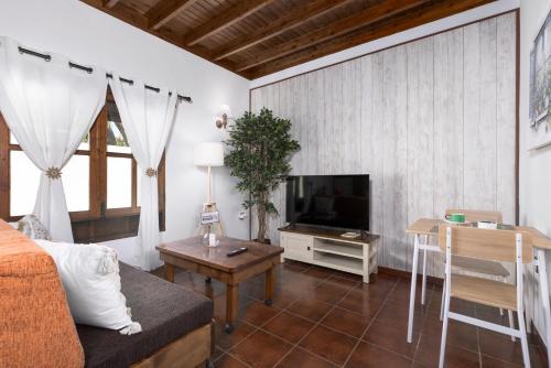 a living room with a couch and a television at Home2Book La Molina B, Cozy Country House in Triquivijate