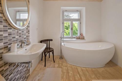 a bathroom with a large white tub and a sink at Gallery loft Myjava Hrachoviste in Hrachovište