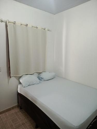a white bed with two pillows in a room at Hotel e Galeria Vizza in Goiânia