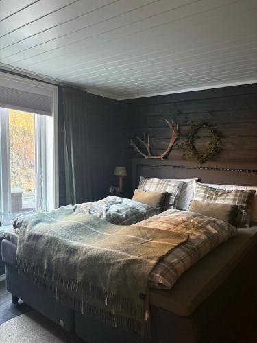 a bedroom with a large bed and a window at VillaElvesus in Vossevangen