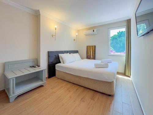 a bedroom with a large white bed and a window at Moonshine Hotel Suites in Bodrum City