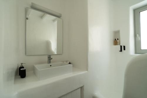 a white bathroom with a sink and a mirror at Villa Tonic by Mykonos Mood in Agios Ioannis Mykonos