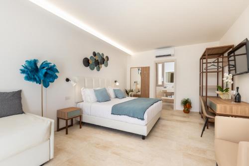 a bedroom with a bed and a desk and a couch at Illumi's Hotel in Villasimius