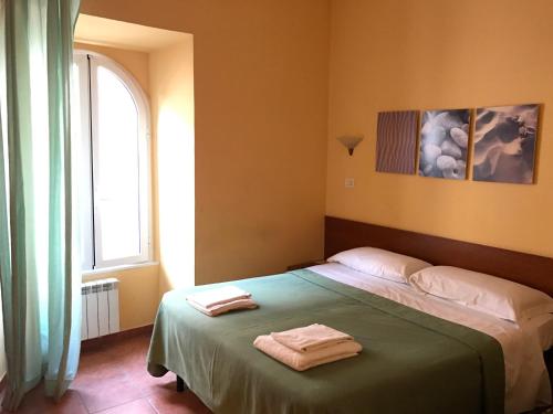een slaapkamer met een bed met twee handdoeken erop bij San Daniele Bundi House in Rome